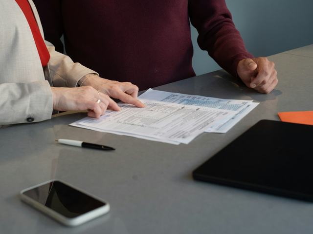 Two people reviewing payroll paperwork together at a desk
